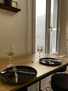 a table with two glasses of wine and a fork and knife at Cocon en vieille ville in Nancy +2 photos