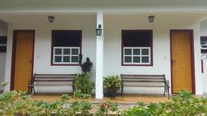 two benches sitting in front of a white building at Pousada da Serrinha in Mariana +14 photos