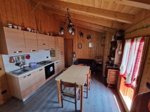 eine Küche mit einem Holztisch in einer Hütte in der Unterkunft Ciapin House in Buglio in Monte