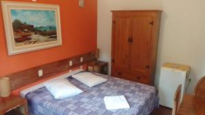 a bedroom with a bed and a painting on the wall at Pousada da Serrinha in Mariana