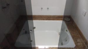 a white bathroom with a tub in a room at Pousada da Serrinha in Mariana