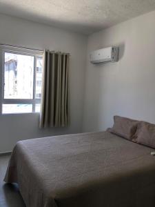 Un dormitorio con una cama y una ventana en Apartamento completo com lazer, en João Pessoa