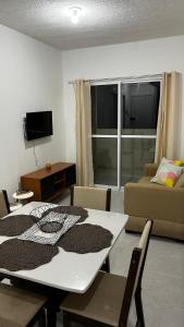 una sala de estar con una mesa y un sofá en Apartamento completo com lazer, en João Pessoa