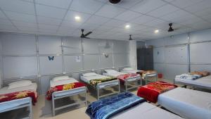 a room with several beds in a room with ceilings at Maa Tarini AC Dormitory in Balasore