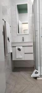 Un baño blanco con lavabo y espejo. en Urban Hostel Mindelo, en Mindelo