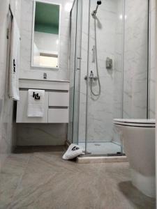 Un baño con ducha, lavabo e inodoro. en Urban Hostel Mindelo, en Mindelo 8 fotos más