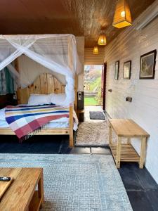 The Soul Stroll Cottages Retreat في مكتزور: غرفة نوم مع سرير وطاولة وسرير سيد