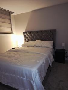 a bedroom with a large bed with a large headboard at Livingston Calgary Lovely space in YYC