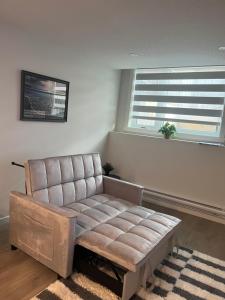 a living room with a couch and two windows at Livingston Calgary Lovely space in YYC