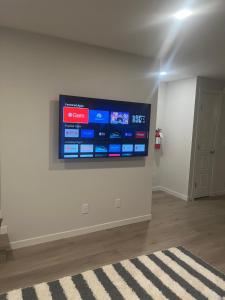 a flat screen tv on a wall in a room at Livingston Calgary Lovely space in YYC +4 photos