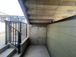 a walkway in a building with stairs and a fence at Livingston Calgary Lovely space in YYC