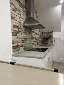 cocina con fregadero y pared de ladrillo en La Casita del abuelo Javi, en Cambados 62 fotos más