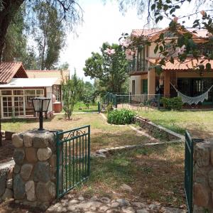 een huis met een poort voor een tuin bij Mya Esencia Espacio Eco Turístico Camping in Tinquipaya