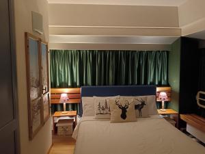 a bedroom with a bed with green curtains at Casa Shabby - Comfortable family apartment near the slopes - Confortevole appartamento per famiglie vicino alle piste in Marilleva +60 photos