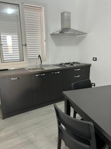 a kitchen with a sink and a table with chairs at BALISTRERI HOUSe in Trabia