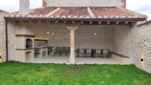 un patio esterno con griglia, tavolo e sedie di La Cantizada a Viloria