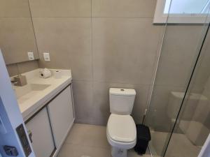 a bathroom with a toilet and a sink and a shower at Praia e mar in Tramandaí +7 photos