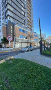 a street with a car parked in front of a building at Praia e mar in Tramandaí