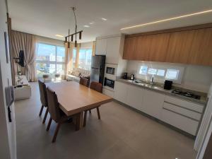 a kitchen with a wooden table and a dining room at Praia e mar in Tramandaí