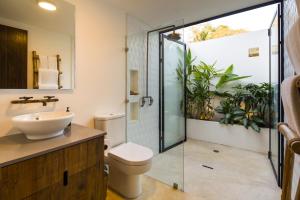 a bathroom with a toilet and a sink and a shower at Nalu Nosara Pool Villa Sol in Playa Guiones