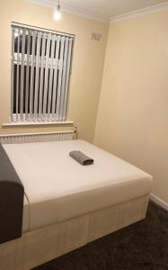a white bed in a room with a window at 3-Bed Home, Free Parking, Smart TV,Family & Business Ready in Slough