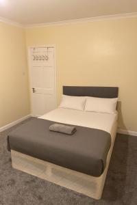 a bedroom with a bed and a white door at 3-Bed Home, Free Parking, Smart TV,Family & Business Ready in Slough