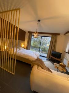 une chambre avec un lit, un canapé et une fenêtre dans l'établissement Au doux Durbuy, à Durbuy 16 autres photos
