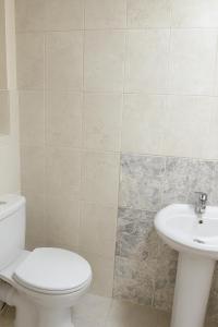 a bathroom with a toilet and a sink at 3-Bed Home, Free Parking, Smart TV,Family & Business Ready in Slough +1 photo