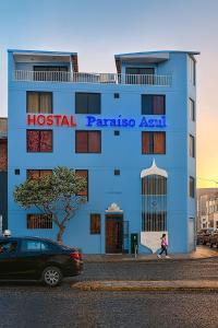 Hostal Paraíso Azul في تروخيو: مبنى أزرق عليه لافتة قديمة لـ pariasosaania