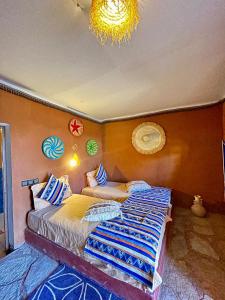 a bedroom with two beds and a chandelier at Aladdin Desert Camp - Mhamid Erg Chigaga Escape in El Gouera