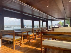 Trinetra Boat House - Dormitory في Honāvar: غرفة طعام على قارب مع طاولات وكراسي