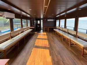 Trinetra Boat House - Dormitory في Honāvar: غرفة بها مقاعد وطاولات ومحيط