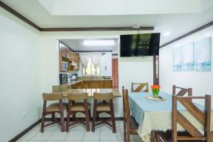 a kitchen and dining room with a table and chairs at Casa del Sol - Poolside Villa in Quepos