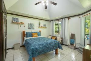 a bedroom with a bed and a ceiling fan at Casa del Sol - Poolside Villa in Quepos +12 photos