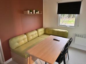 a living room with a couch and a wooden table at Tinyhouse 6 Ferienwohnung Mobilheim Fehmarn in Fehmarn