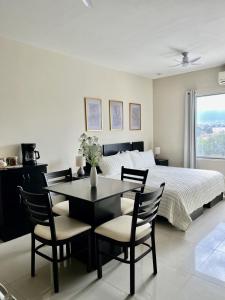 Loft con Luz Natural y Cocina Equipada في سالتيلو: غرفة نوم بها سرير وطاولة وكراسي