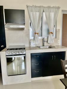 Loft con Luz Natural y Cocina Equipada في سالتيلو: مطبخ مع موقد ومغسلة