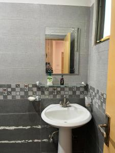 ein Badezimmer mit Waschbecken und Spiegel in der Unterkunft Syed Apartment 302 in Islamabad + 3 Fotos