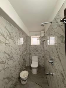 un baño con inodoro y lavabo en S ROOMs, en Pithāpuram