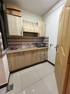 eine Küche mit Holzschränken und einer Arbeitsplatte in der Unterkunft Syed Apartment 302 in Islamabad