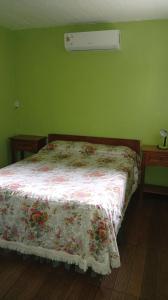 een slaapkamer met een bed met een bloemdekbed erop bij LAPOSTa555 in Piriápolis