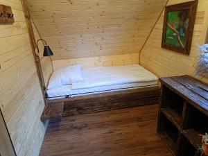 Łowisko Źródła Chatka Zimorodka : غرفة صغيرة بسرير في كابينة خشبية