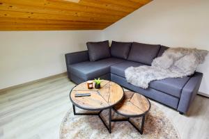 a living room with a couch and a table at Gemütliche Ferienwohnung im DG am Tegernsee - Bergblick, Ruhe & ganz viel Platz in Bad Wiessee