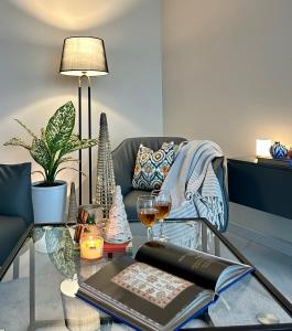 ein Wohnzimmer mit einem gläsernen Couchtisch und Weingläsern in der Unterkunft Tashkent City Downtown Deluxe Host Apartments in Taschkent