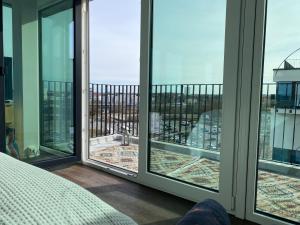a room with a bed and windows with a view at Helles Apartment über den Dächern Rostocks in Rostock