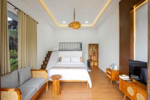 a bedroom with a bed and a couch and a television at The Full Hot Spring & Resort in Kemloko-gede