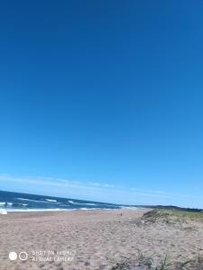 a sandy beach with the ocean in the background at LAPOSTa555 in Piriápolis +7 photos
