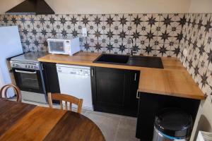 una cocina con encimera y microondas en Les Chambres de MARIE, en Villié-Morgon 27 fotos más