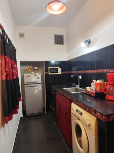 una pequeña cocina con fregadero y lavavajillas en Casa vacacional 6 personas, en Santa Teresita