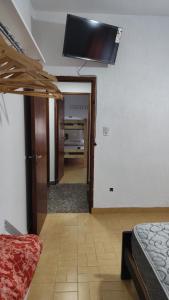 Una sala de estar con un televisor de pantalla plana en el techo. en Casa vacacional 6 personas, en Santa Teresita